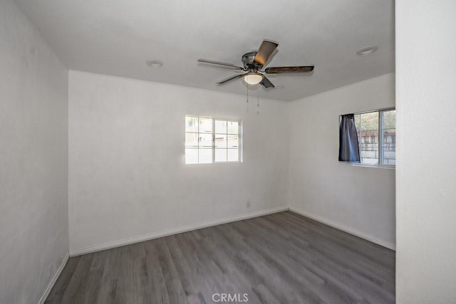 empty room featuring dark wood-type flooring and ceiling fan