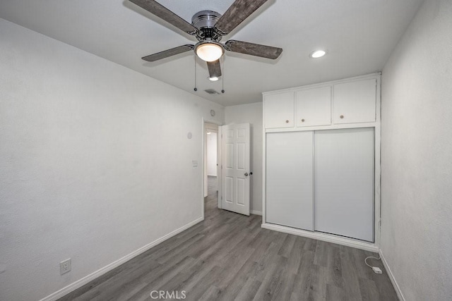 unfurnished bedroom featuring ceiling fan, light hardwood / wood-style floors, and a closet