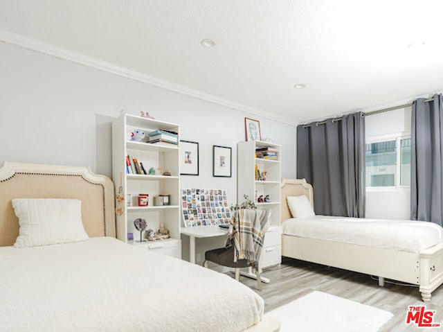 bedroom featuring light hardwood / wood-style floors and crown molding