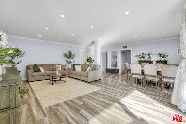 living room with light wood-type flooring and ornamental molding