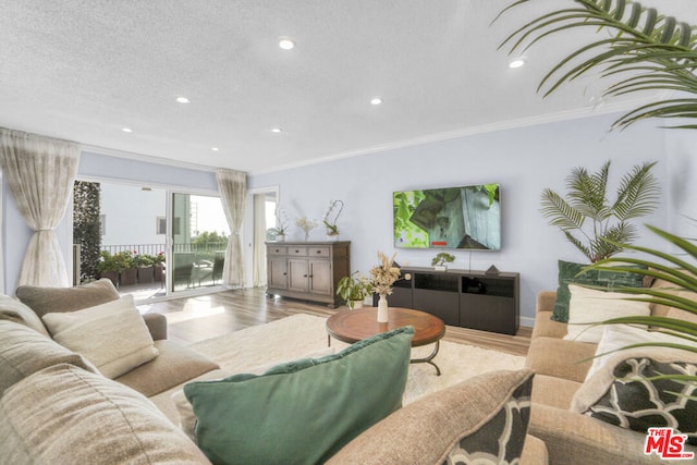 living room with a textured ceiling, wood-type flooring, and crown molding