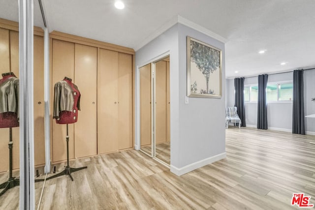 corridor featuring light hardwood / wood-style flooring and crown molding