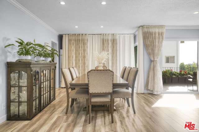 dining space featuring a textured ceiling, light hardwood / wood-style flooring, and crown molding