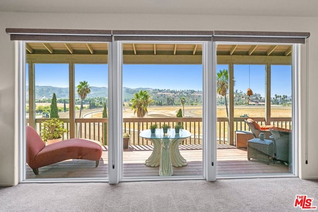 doorway with a mountain view and carpet floors