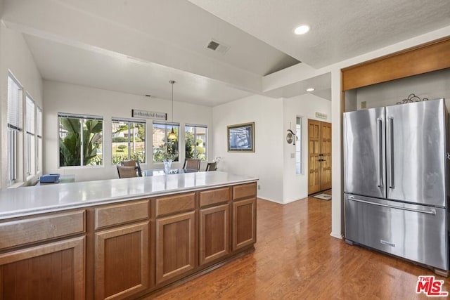 kitchen featuring hanging light fixtures, dark hardwood / wood-style floors, vaulted ceiling, and high end fridge