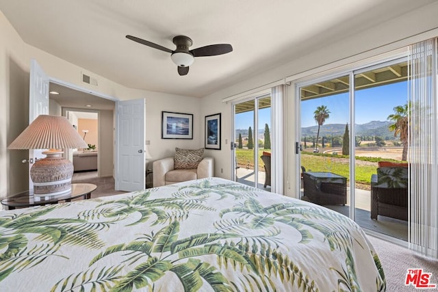 bedroom featuring access to outside, a mountain view, carpet flooring, and ceiling fan