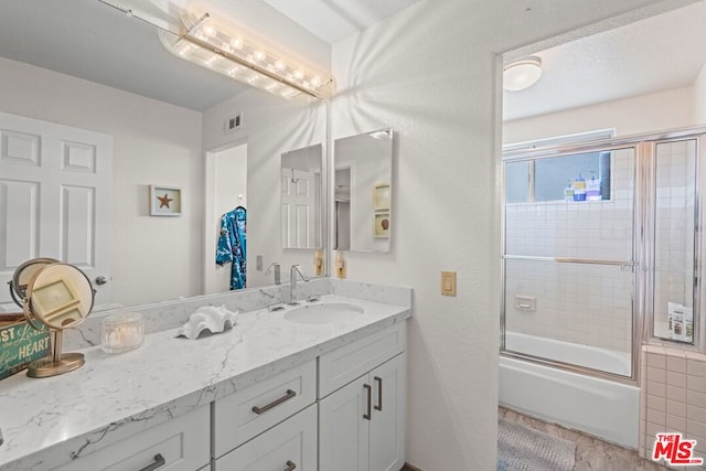 bathroom featuring vanity and shower / bath combination with glass door