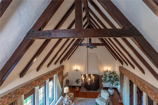 living room with beamed ceiling, hardwood / wood-style floors, high vaulted ceiling, and a notable chandelier