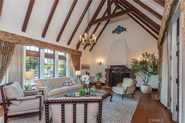 living room featuring hardwood / wood-style floors, high vaulted ceiling, a fireplace, beamed ceiling, and a chandelier