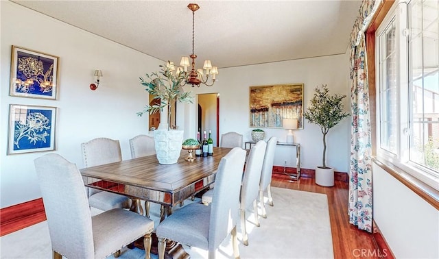 dining room with hardwood / wood-style floors and a notable chandelier