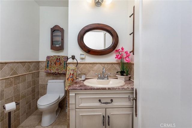 bathroom with tile patterned flooring, vanity, tile walls, and toilet