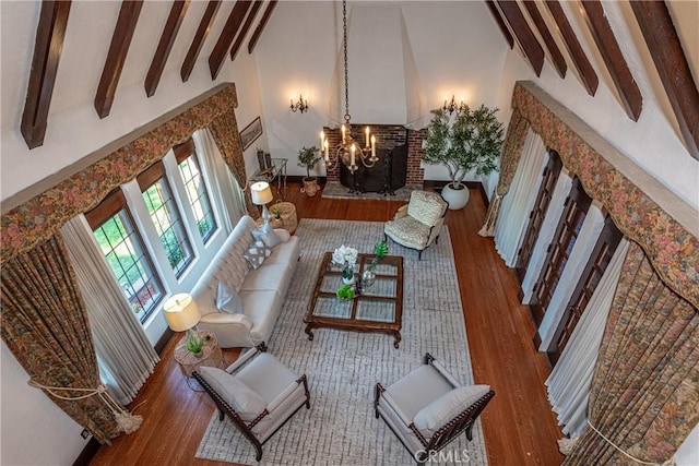 living room featuring beamed ceiling, high vaulted ceiling, hardwood / wood-style floors, and a notable chandelier