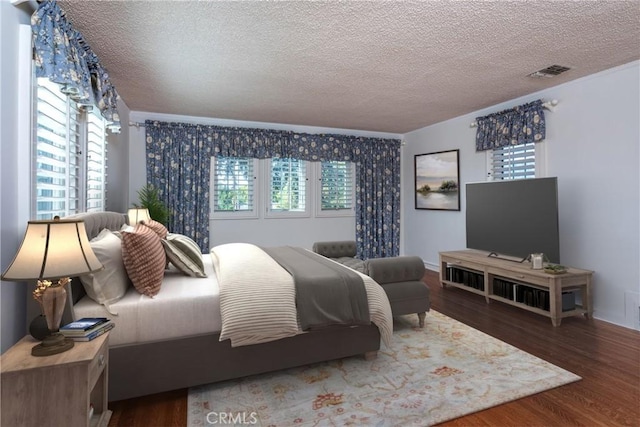 bedroom featuring dark hardwood / wood-style flooring, a textured ceiling, and multiple windows