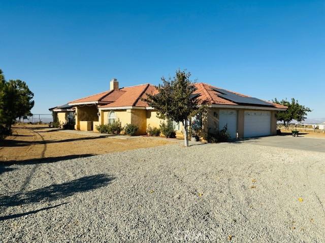 single story home with solar panels and a garage