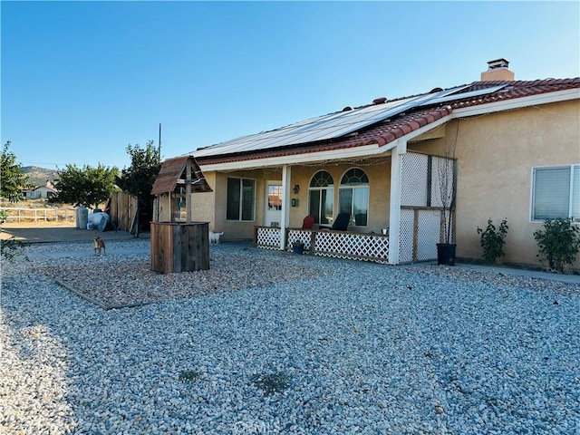 view of front facade with covered porch and solar panels