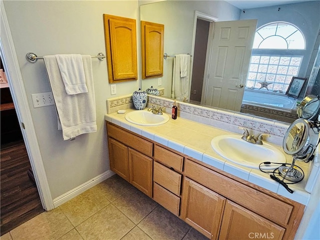 bathroom featuring tile patterned flooring, vanity, and a bath