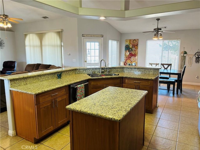 kitchen with light stone countertops, sink, dishwasher, a large island, and light tile patterned flooring