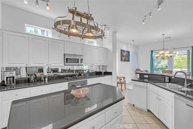 kitchen featuring a notable chandelier, stainless steel appliances, plenty of natural light, and white cabinetry