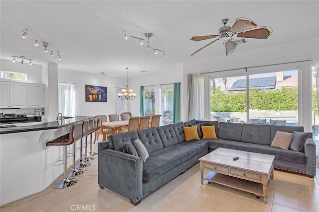 living room with ceiling fan with notable chandelier and light tile patterned floors