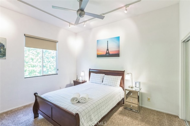 bedroom featuring rail lighting, carpet, and ceiling fan