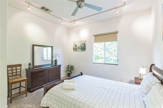 bedroom with light carpet, ceiling fan, and track lighting