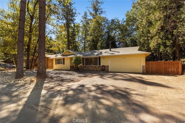 6131 Dana Cir, Magalia, CA 95954 - view of front of house featuring dirt driveway, an attached garage, and stone siding
