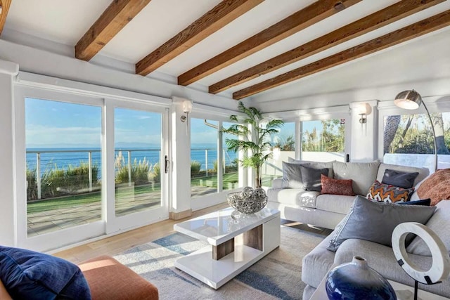 sunroom featuring lofted ceiling with beams and a water view