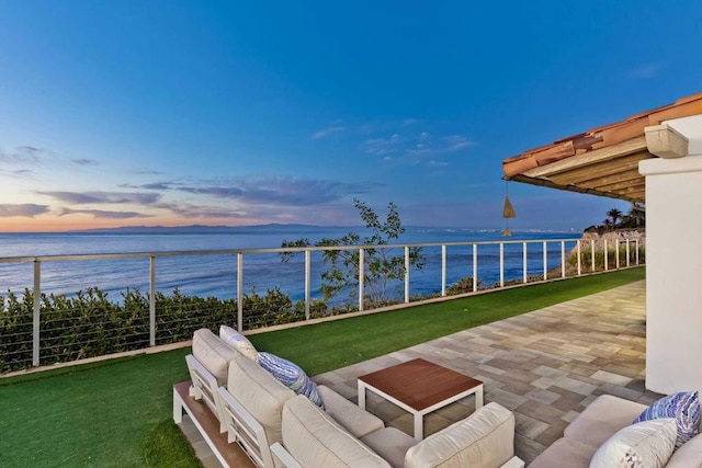 patio terrace at dusk featuring a water view