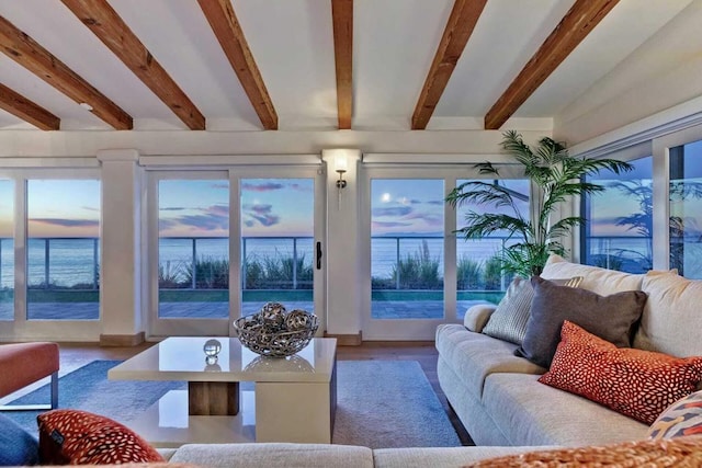 living room featuring beam ceiling and a water view