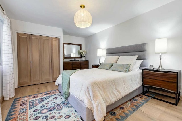 bedroom with light wood-type flooring and a closet