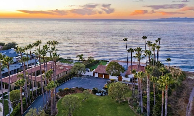 aerial view at dusk featuring a water view