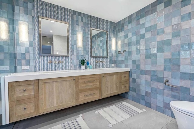 bathroom featuring tile patterned flooring, vanity, tile walls, and toilet