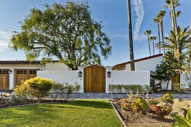 mediterranean / spanish house featuring a front yard and a garage