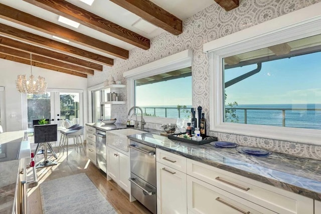 kitchen with white cabinets, hardwood / wood-style floors, a water view, and dark stone counters