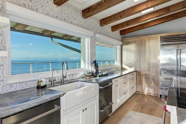 kitchen featuring a water view, sink, light hardwood / wood-style floors, white cabinetry, and stainless steel appliances