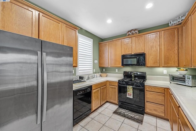 kitchen with black appliances, light tile patterned flooring, and sink