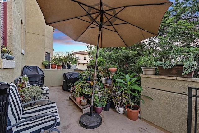 patio terrace at dusk featuring a grill