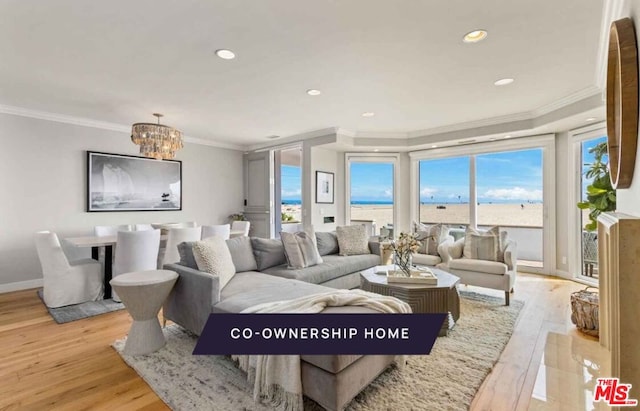 living room featuring ornamental molding, light hardwood / wood-style floors, and a notable chandelier