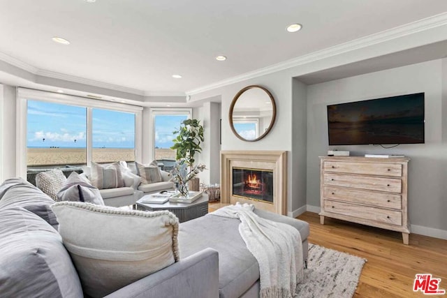 living room with light hardwood / wood-style flooring, a water view, and crown molding