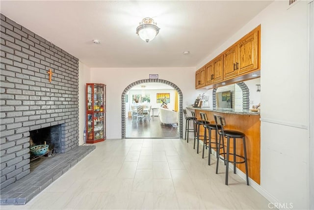 kitchen with a breakfast bar and a fireplace