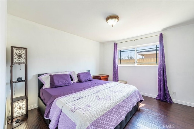 bedroom with dark hardwood / wood-style floors