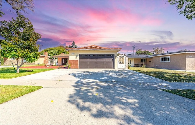 view of front of home with a garage and a lawn