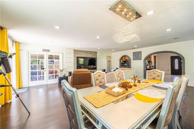 dining area with french doors, dark wood-type flooring, and a notable chandelier