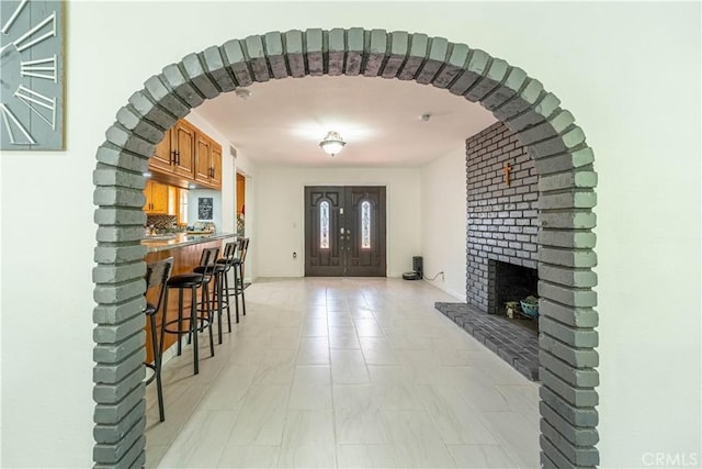 foyer entrance with a brick fireplace