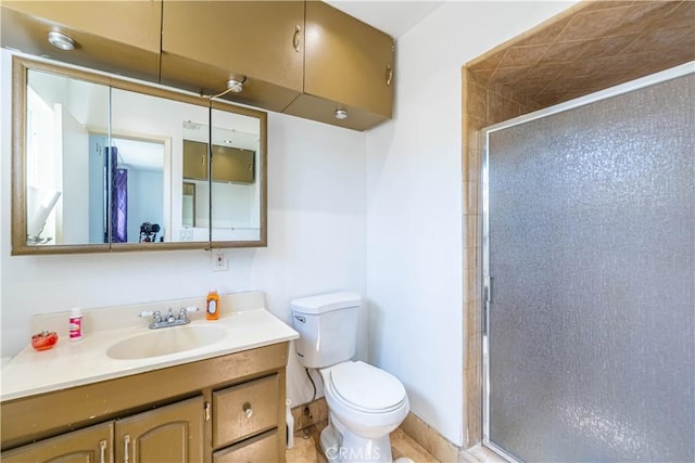 bathroom with vanity, toilet, and a shower with door