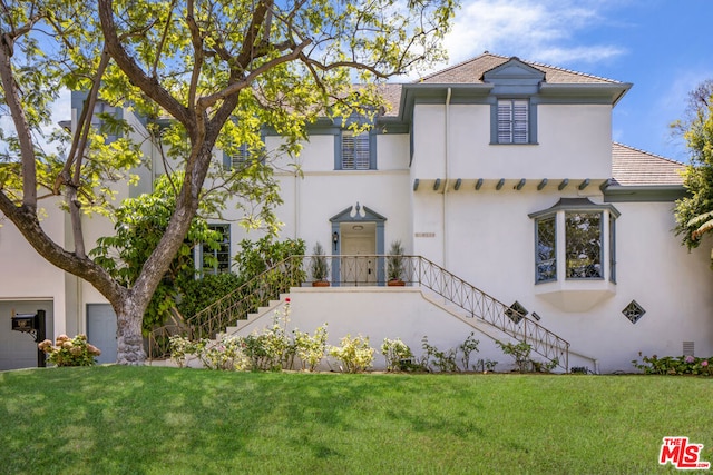 view of front of property featuring a garage and a front lawn