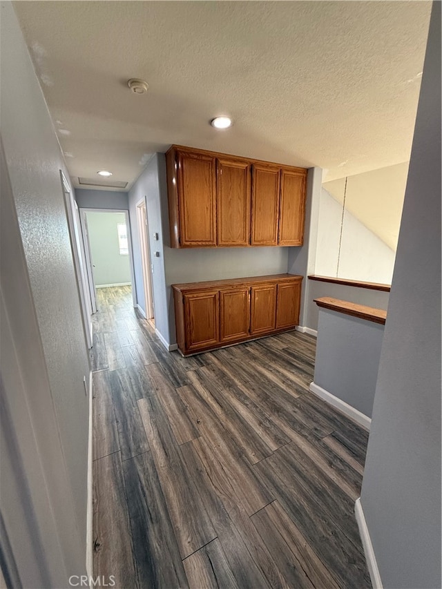 kitchen with a textured ceiling and dark wood-type flooring