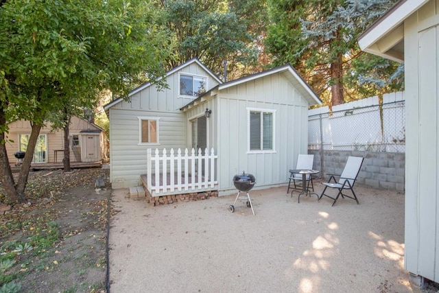 rear view of house featuring a storage unit and a patio area