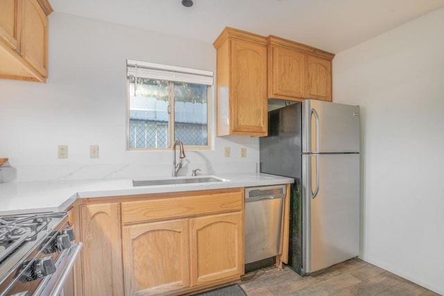 kitchen featuring appliances with stainless steel finishes, light brown cabinetry, sink, and hardwood / wood-style flooring