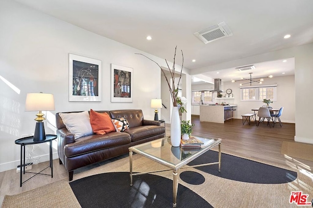 living room featuring a chandelier and light wood-type flooring